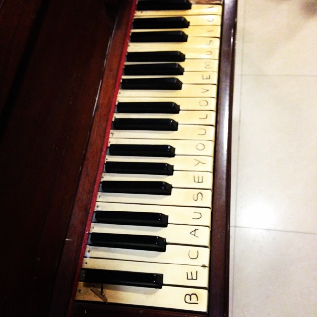 Piano keys inscribed with Because You Love Music